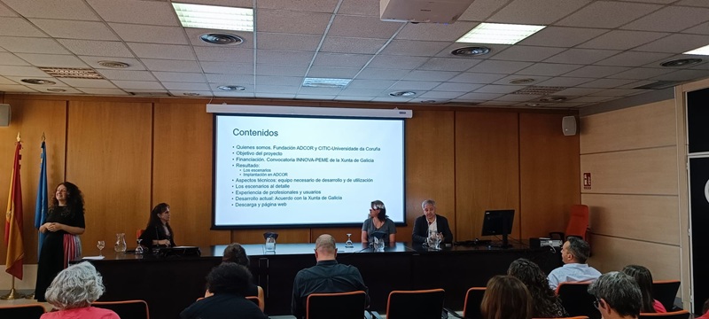 Personas en mesa dando una ponencia. Se ve también a una interprete de lengua de signos.
